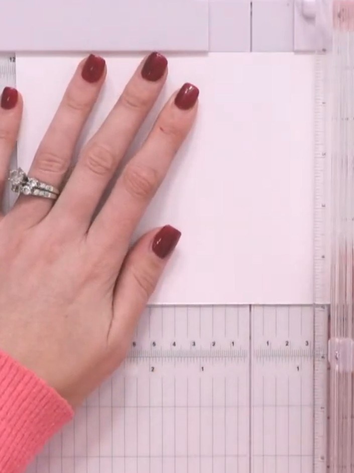 Step 1: Place your white cardstock into the scoring board. Use the scoring tool to create evenly spaced horizontal sco