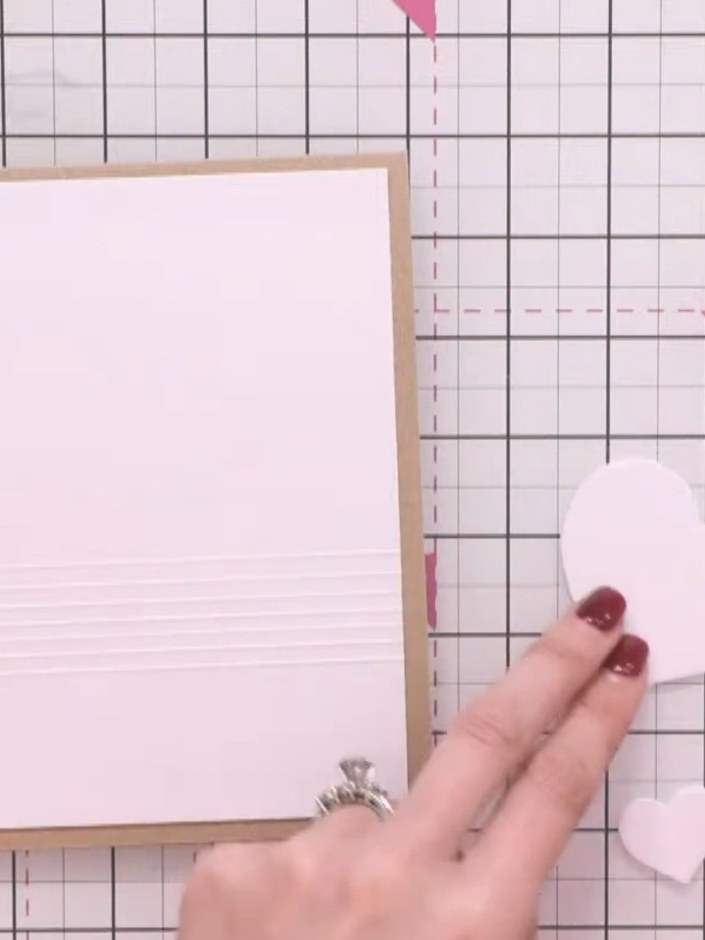 Step 3: Use the embossing folder to create multiple embossed lines across the pink card panel. Continue embossing line