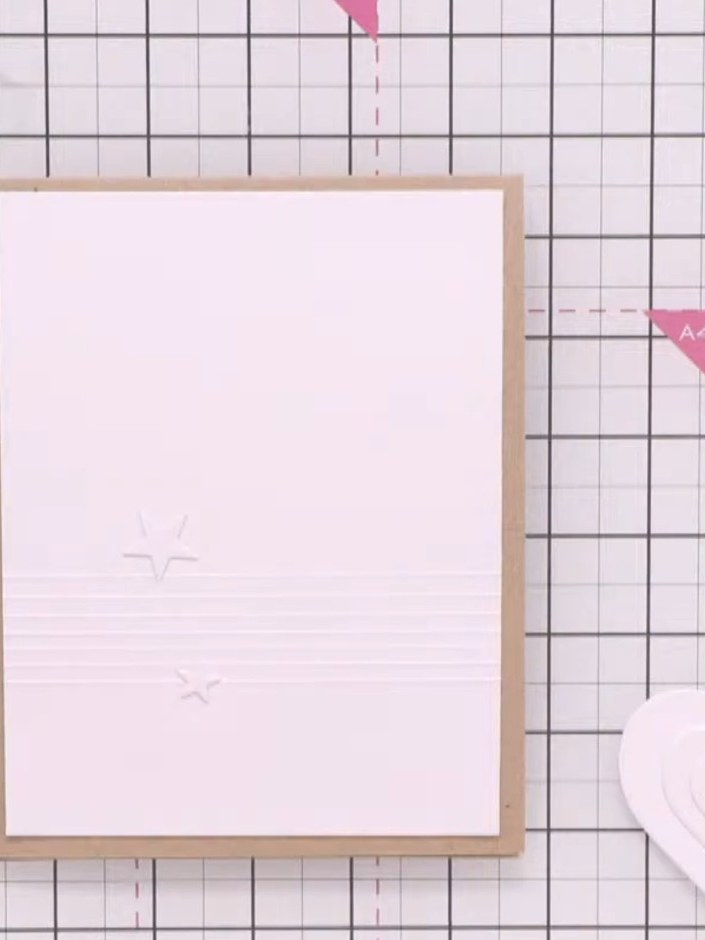 Step 7: Klebe das geschichtete Herzelement mit Abstandspads auf das geprägte weiße Panel, damit es schön dreidimensional wirkt.