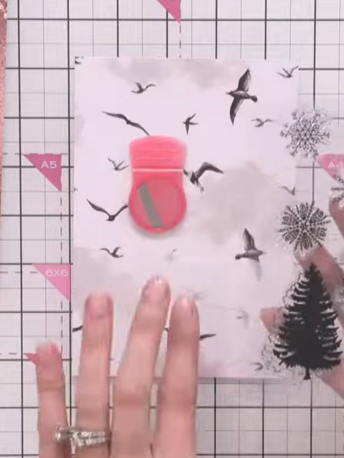 Step 3: Stamp tree designs along the base of the card using brown distress ink, positioning them to create a forest li
