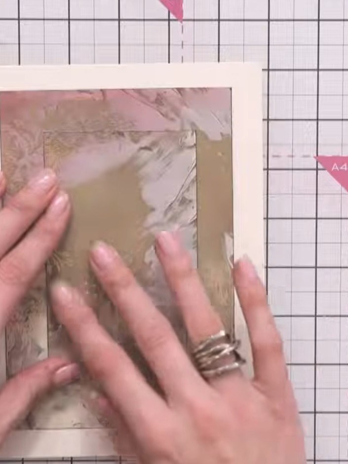 Step 10: Adhere the patterned paper layer to the cream card base. Smooth down firmly to ensure it is completely flat wi