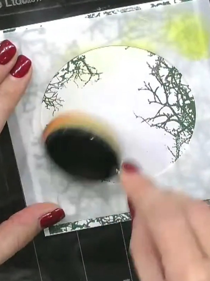 Step 5: Position a circular stencil in the centre of your stamped card. Blend yellow ink across the stencil opening to