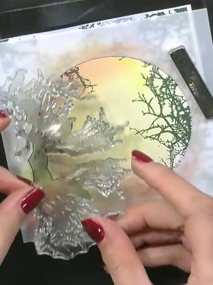 Step 1: Position your circular stencil on the card to act as a mask. Hold it firmly in place with your hand to prevent