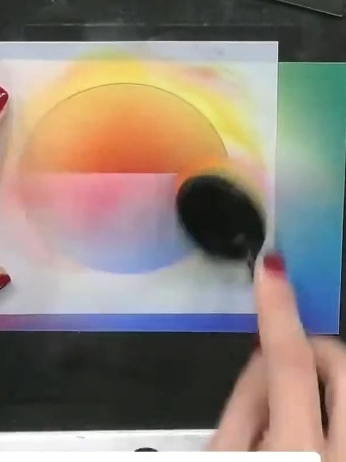 Step 7: Use a blending brush or sponge to stipple white ink across the lower half of the rainbow gradient panel to cre