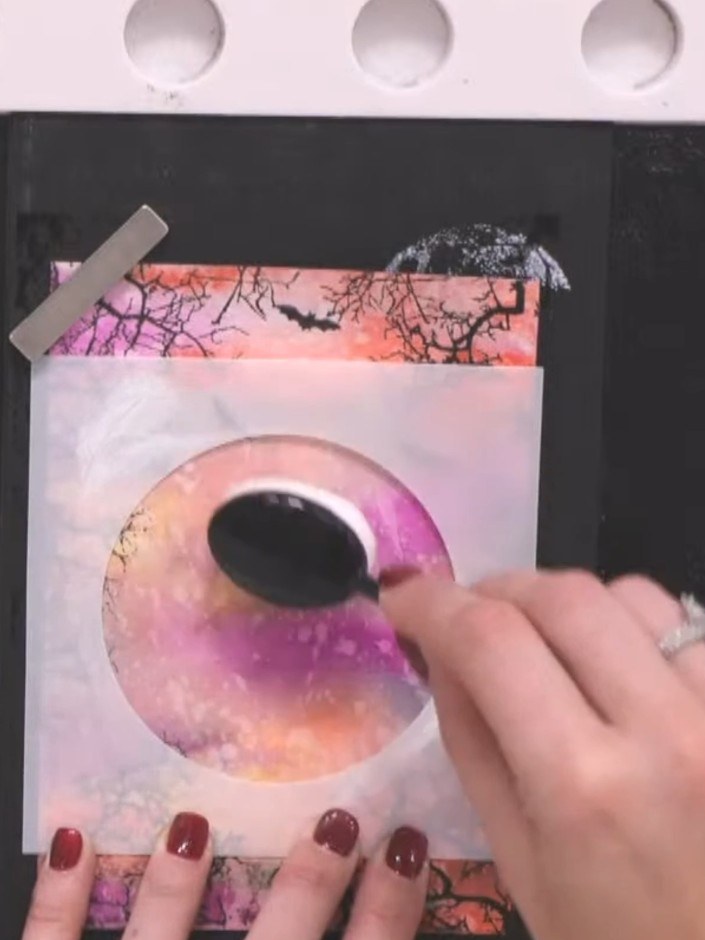 Step 12: Stamp the reflection children figures in the centre of the card using black ink, positioning the reflection be