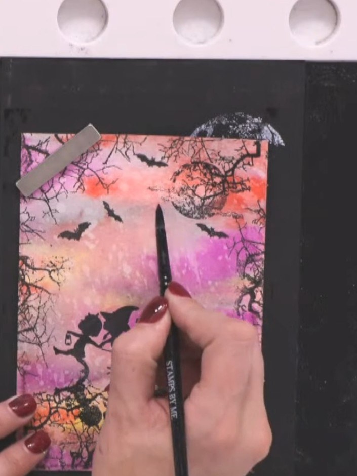 Step 14: Using a wet brush, paint water onto the moon area and create radiating lines outward. Lift the wet areas with 