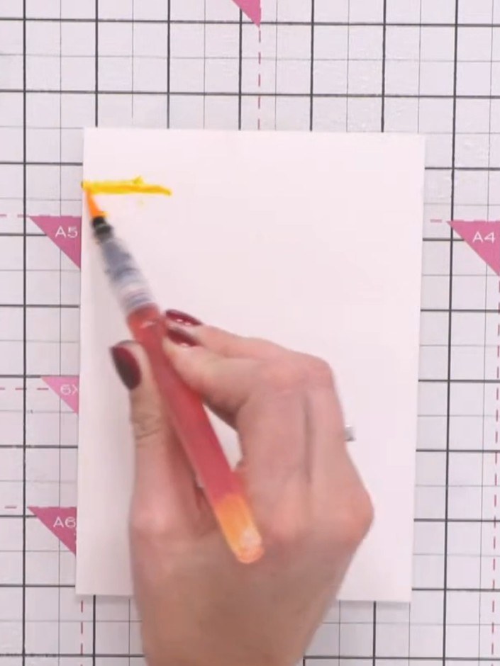 Step 6: Allow the card to dry slightly, then add more colour layers using the water brush pens. Repeat the spray and b