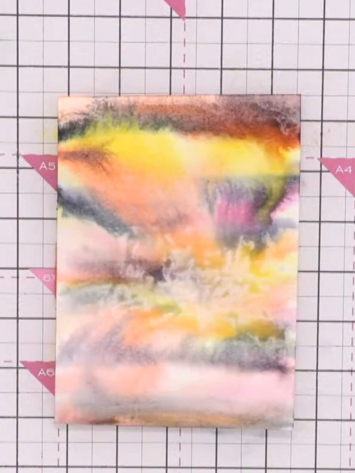 Step 8: Use a piece of tissue paper to lift out colour from the areas where you flicked water, creating bleached spots