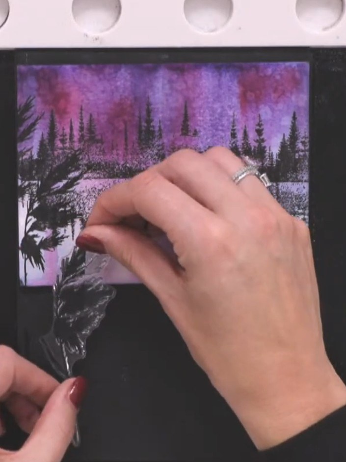 Step 10: Stamp the moon onto the scene using a white ink pad, tapping lightly to create a textured effect. Position the