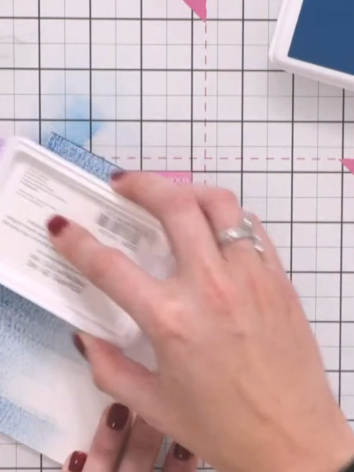 Step 3: Gently tap the card to allow the water and ink to blend together, creating an atmospheric effect with the purp