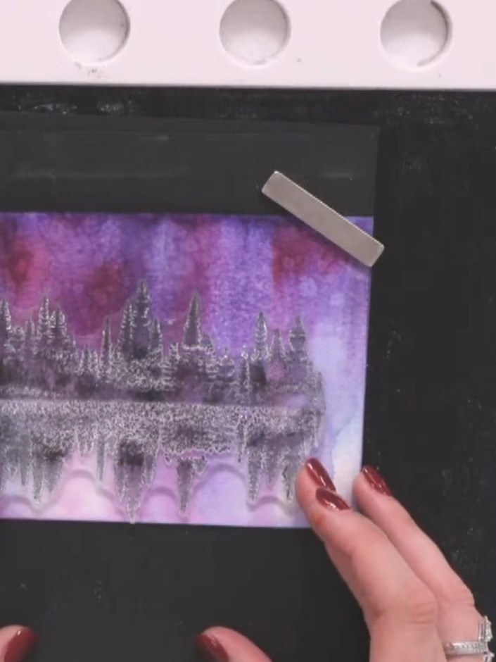 Step 8: Stamp the silhouette tree images in black ink across the purple and pink background, overlapping them slightly