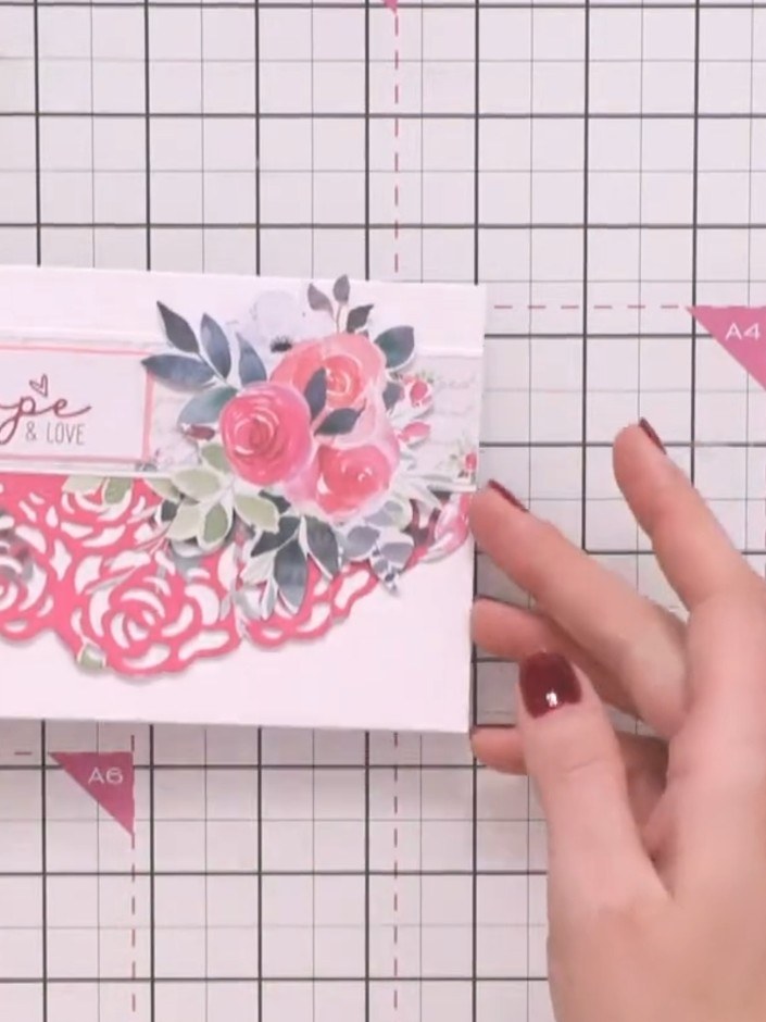 Step 7: Adhere the 'hope & love' sentiment to the upper portion of the card above the floral arrangement to complete y