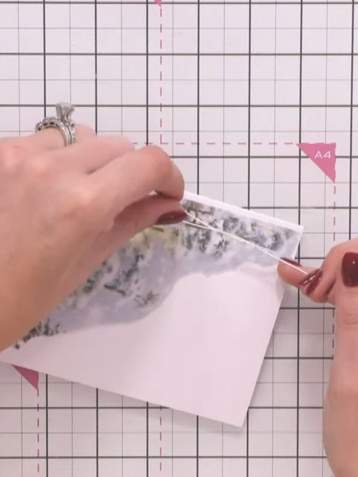 Step 5: Hold the decorative vellum panel in place at the top of the card and secure it with a small bow tied from gold
