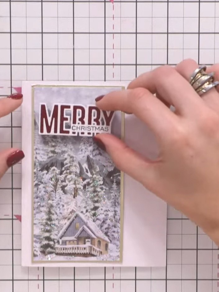 Step 5: Stamp the 'Merry Christmas' sentiment in red ink at the top of the card panel, positioning it centrally above 
