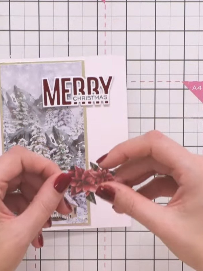 Step 6: Cut out a poinsettia design from the A Winter Story paper pad. Position and attach it as an embellishment on t