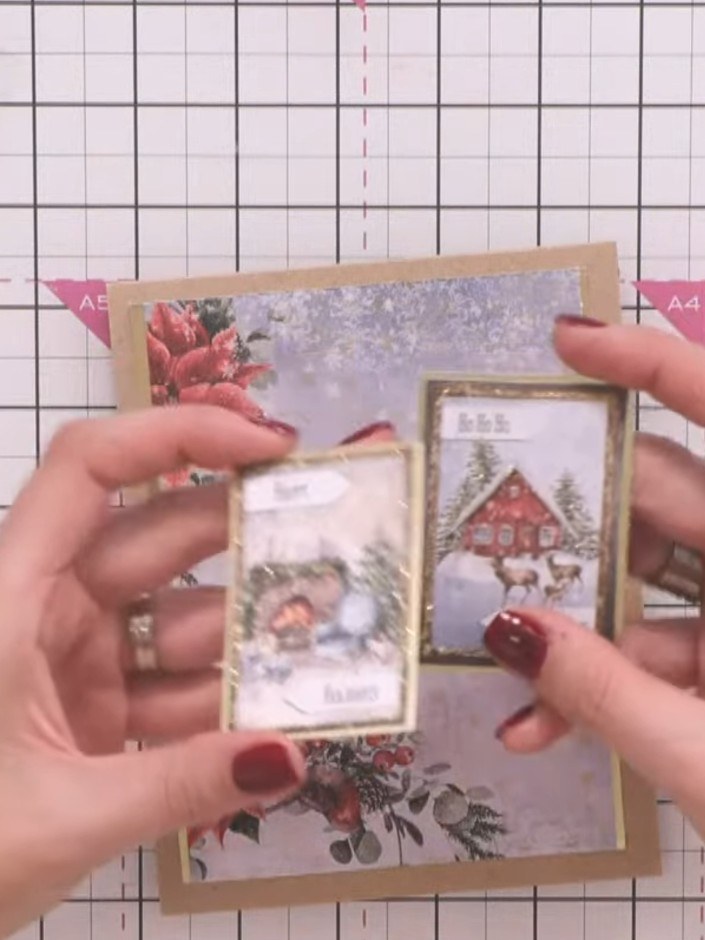 Step 3: Position two small rectangular toppers with winter scenes (snowman and house) onto the card front with gold bo