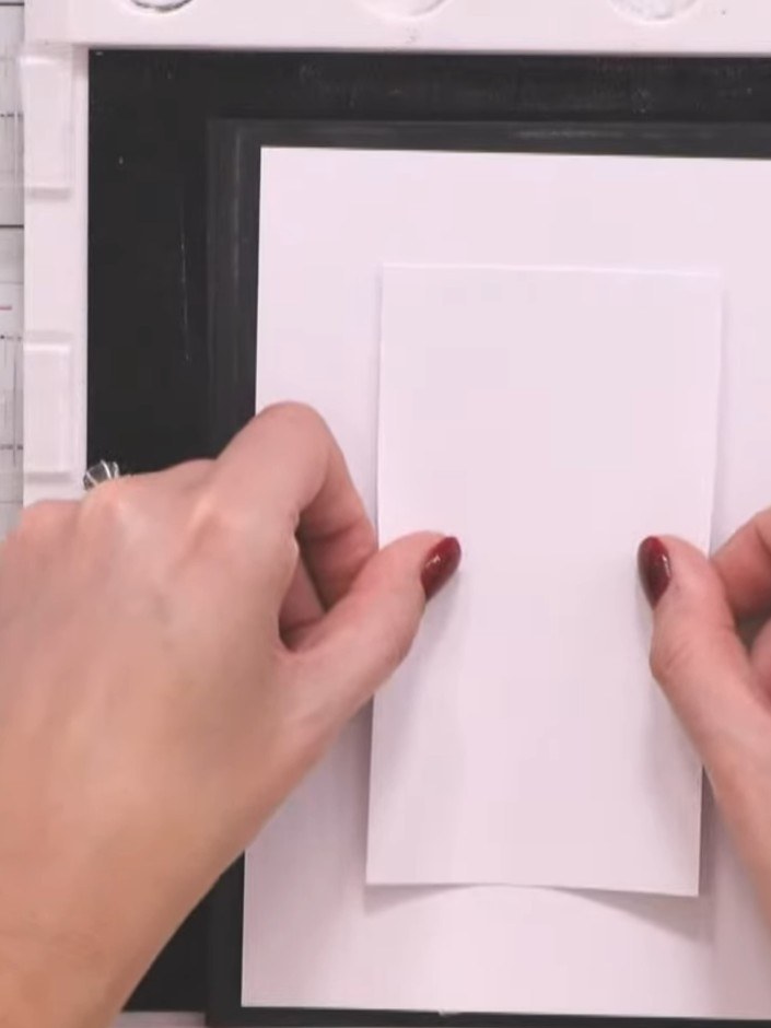 Step 2: Position the smaller white piece centrally on the larger white piece. Temporarily secure it in place using a t