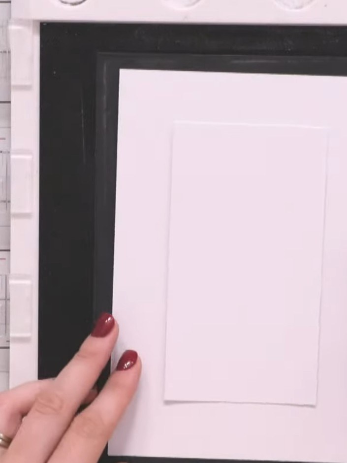 Step 3: Coloca el panel de cartulina blanca en una herramienta de posicionamiento para estampar, así no se moverá mientras estampas.