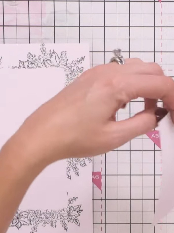 Step 9: Secure the pink-backed floral frame to your card base using adhesive. Position it centrally on the front of th