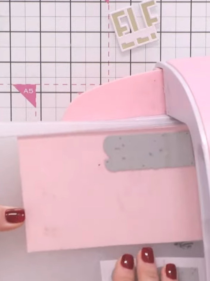 Step 5: Layer the white underplate behind the pink outlined greeting piece. Feed both pieces together through your die