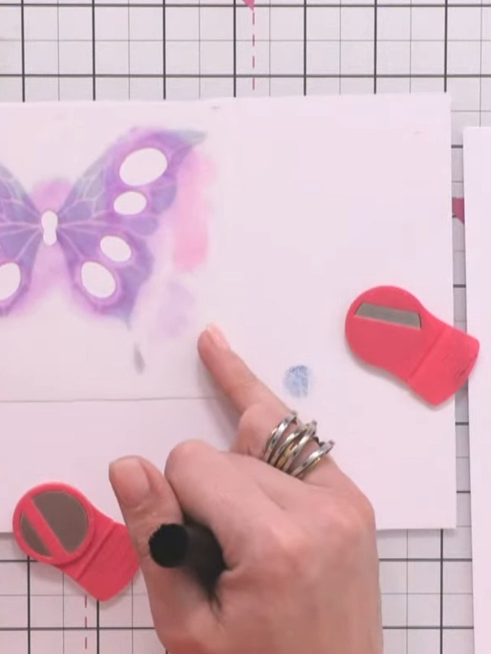 Step 4: Position stencil number three over the butterfly and apply pink ink through the eye details using a blending b