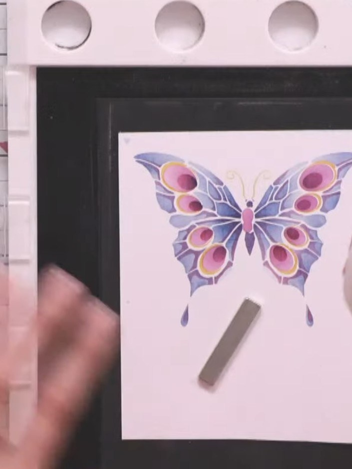 Step 7: Dust the stamped butterfly image with anti-static powder using the anti-static pouch. Apply metallic copper em
