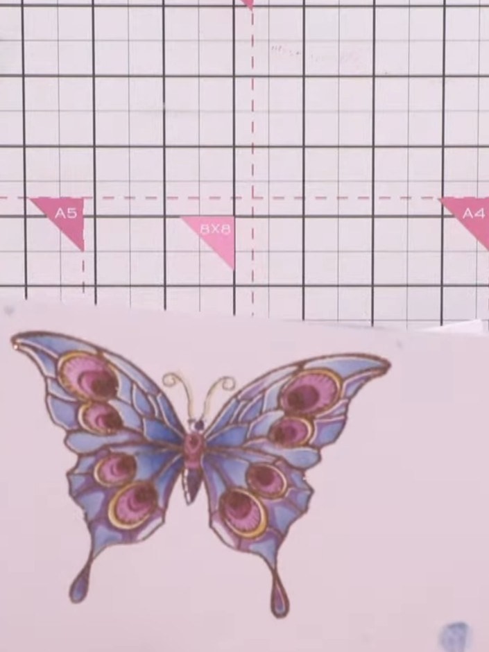 Step 8: Heat set the embossing powder with a heat gun, moving it over the butterfly design until the powder melts and 