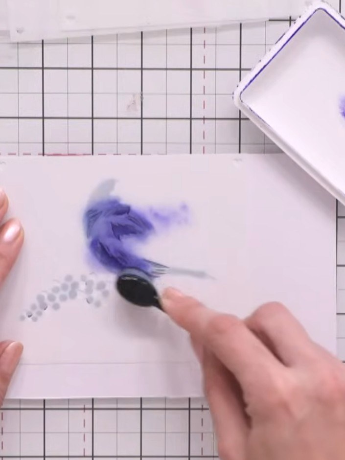 Step 5: Use a blending tool or sponge to apply purple ink through the stencil, adding berries and buds around the stam