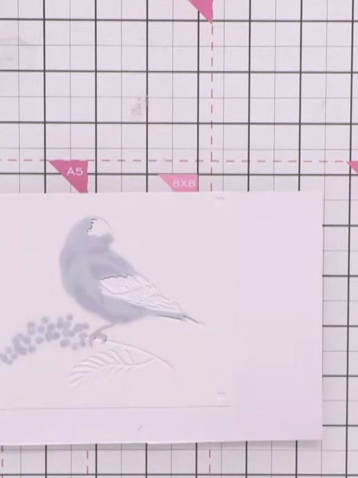 Step 8: Use the fifth stencil layer with black ink to add definition to the bird's eye and tail feathers. Position the