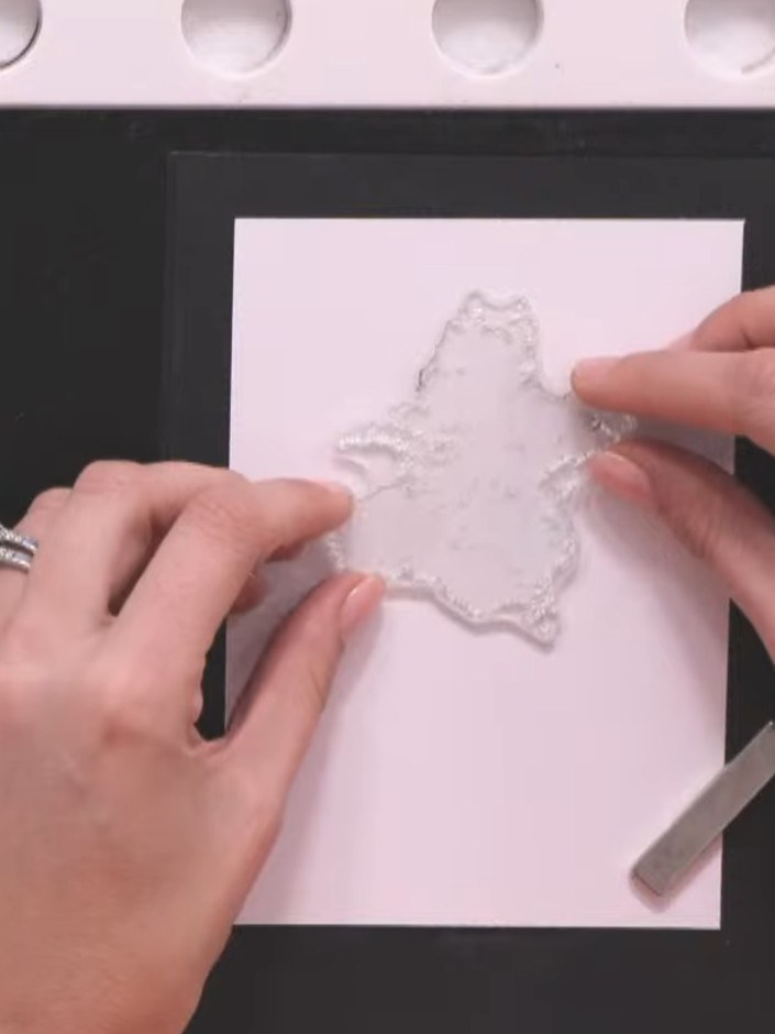 Step 3: Remove the distressed stamp image from the backing. Position it on the white cardstock panel, leaving space ar