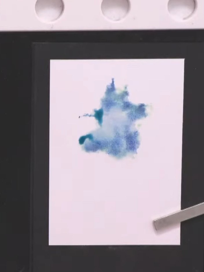 Step 6: Carefully lift the stamp away from the card to reveal the watercolour wash background showing the ship design 