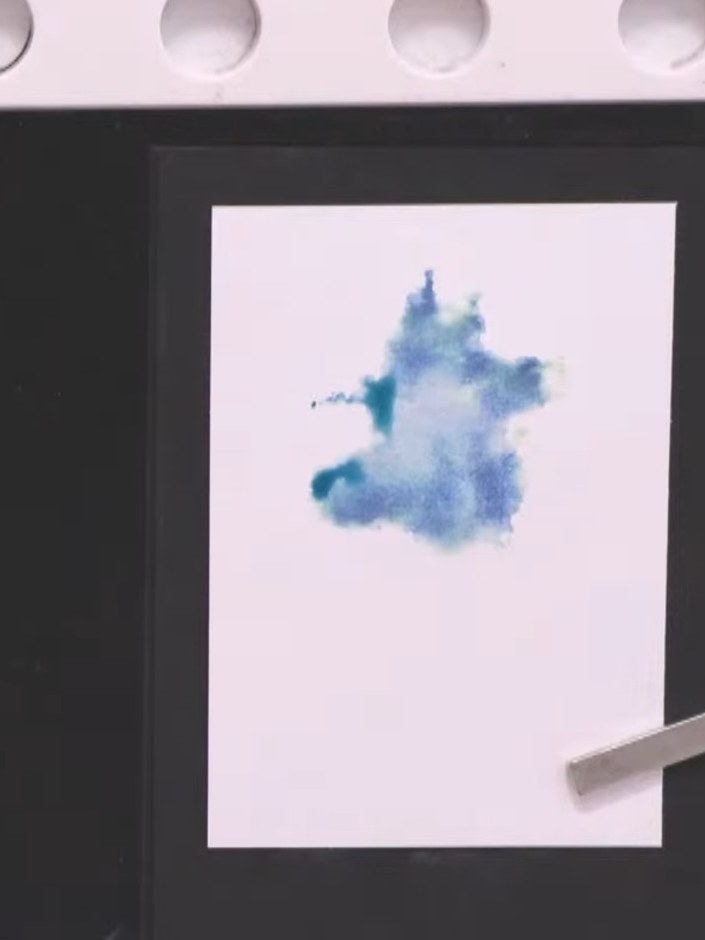 Step 7: Allow the watercolour to dry slightly. The blue watercolour star shape should begin to set on the white card b
