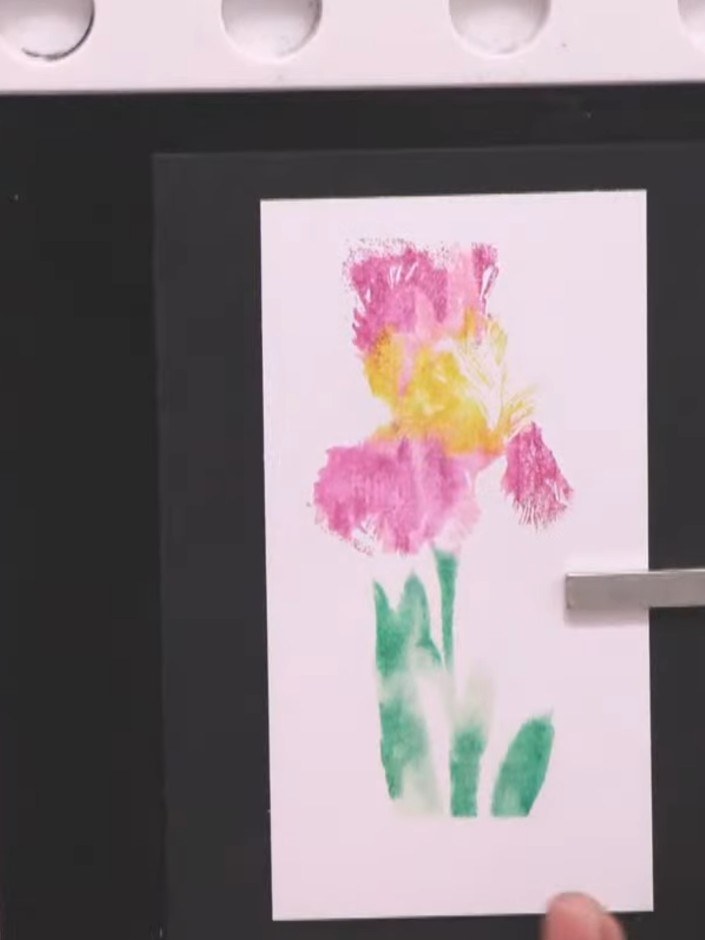 Step 7: Carefully lift the stamp away from the card to reveal the watercolour wash background showing the pink and yel