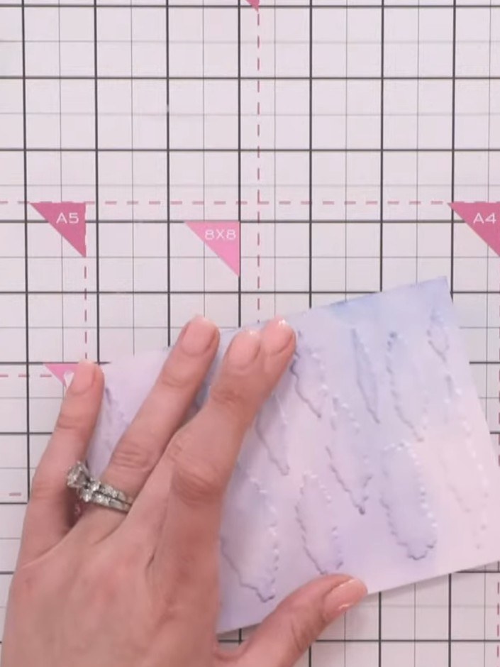 Step 8: Offset the stencil slightly and add additional cloud shapes using the same blue ink to create depth and variat