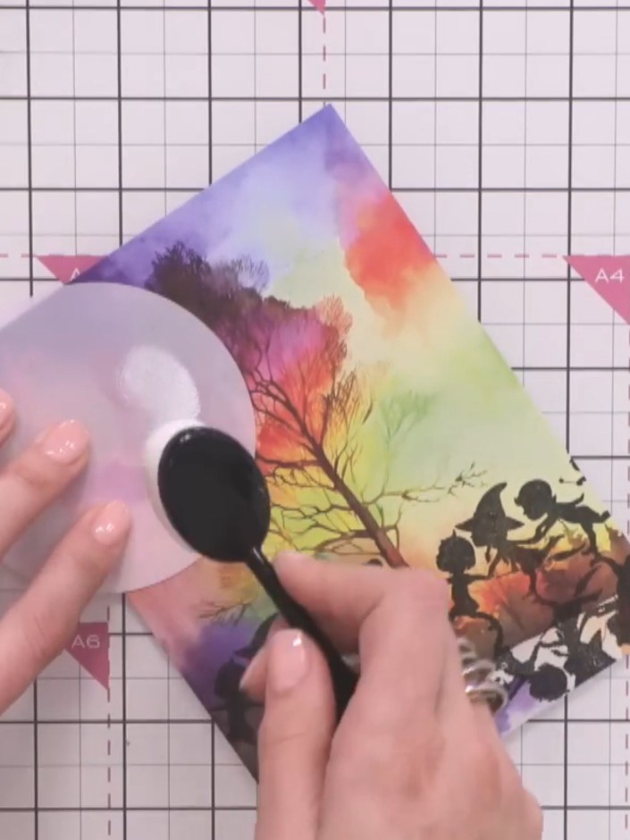 Step 6: Load white ink onto a stencil brush and tap it around the stencil opening to create a moonlit halo effect arou