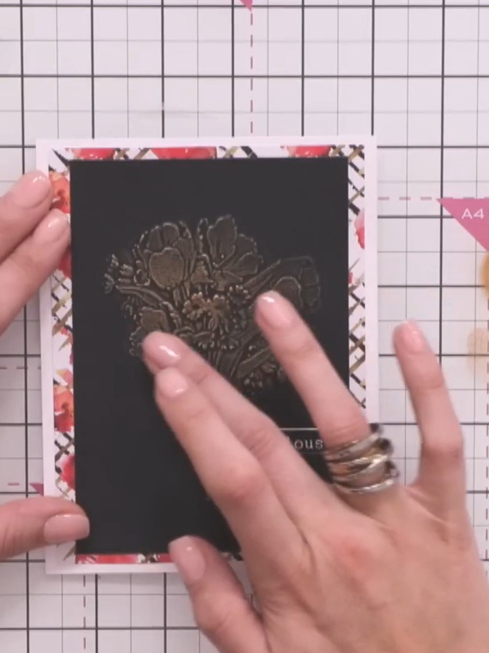 Step 4: Press the black cardstock firmly into the embossing folder to transfer the wax design and create the embossed 