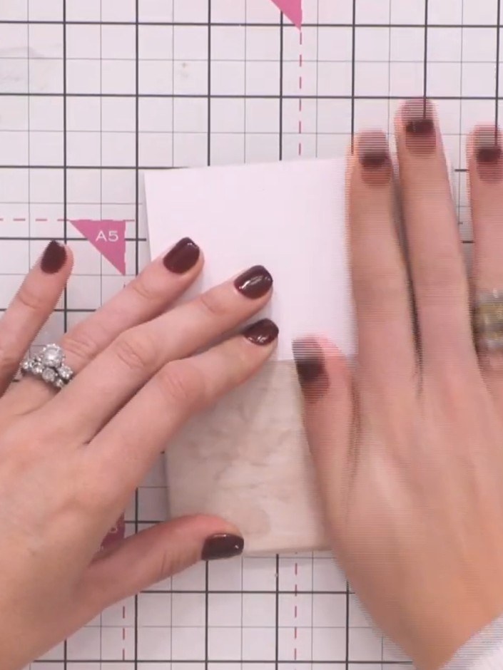 Step 2: Position the vellum sheet over the front of the card base and smooth it down with your hands. Ensure the vellu