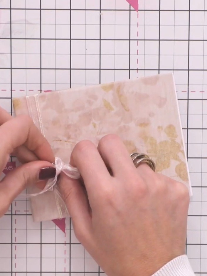 Step 6: Adjust the bow so it sits to one side of the vellum pocket. Trim the ribbon tails to your desired length using