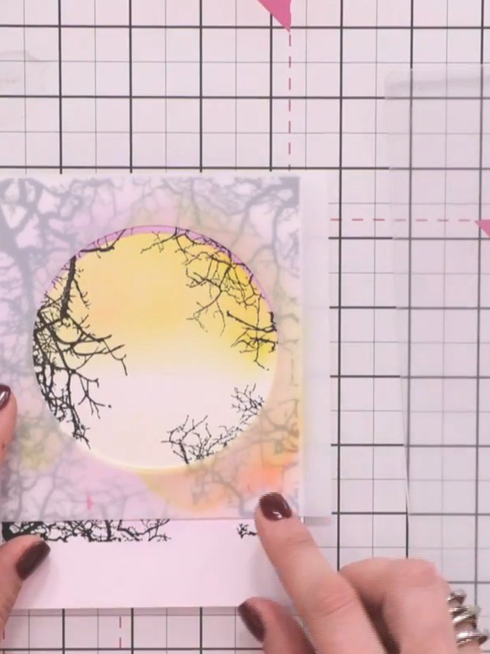 Step 9: Position the stencil back over the card to create a window frame. Stamp the reflection figures from the collec