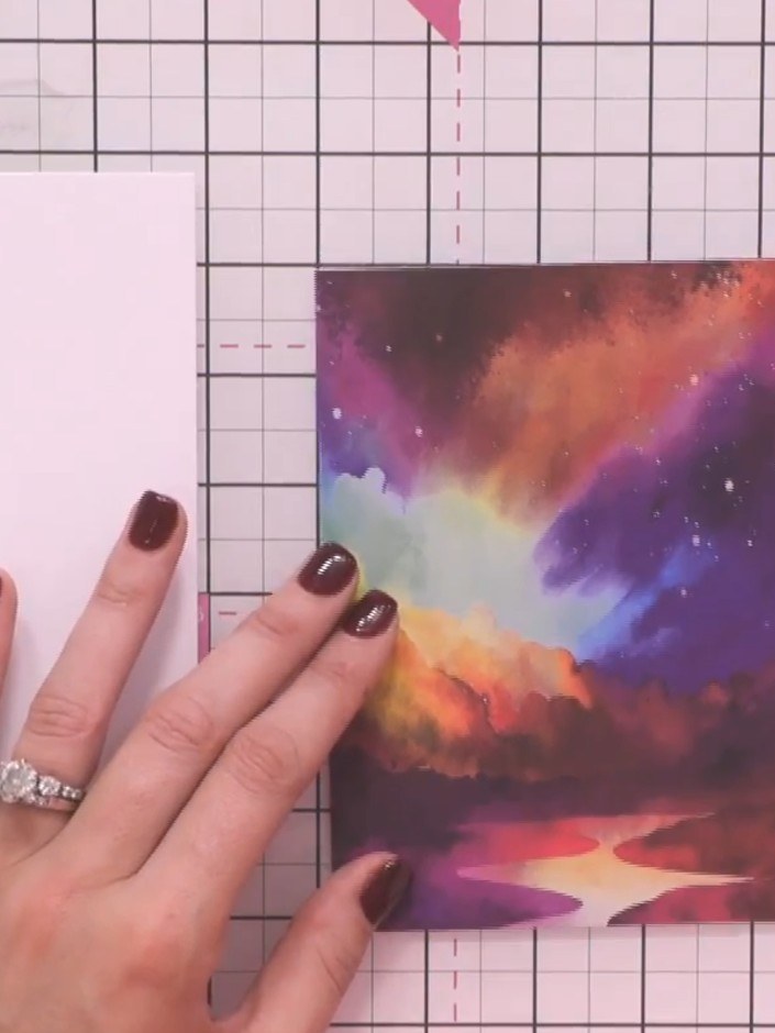 Step 1: Select a decorative paper from the Reflection Collection featuring a colourful atmospheric sky scene. Place it