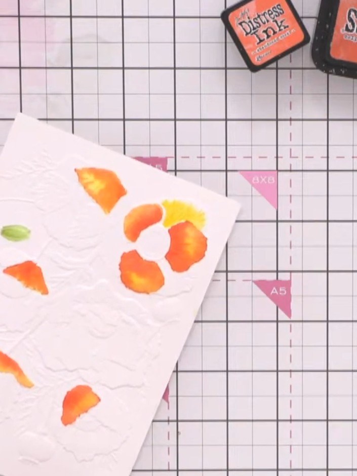 Step 9: Once the watercoloured card is completely dry, swipe a white ink pad over the embossed lines to bring back det
