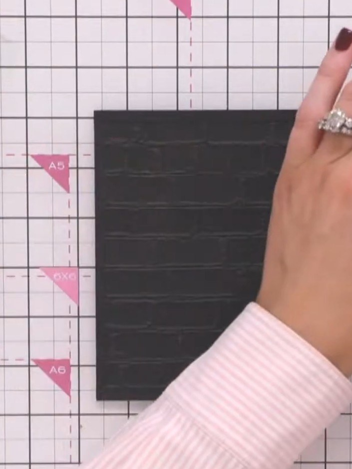 Step 8: Apply gilding wax across the embossed brick texture on the back of the card panel, using your finger to lightl