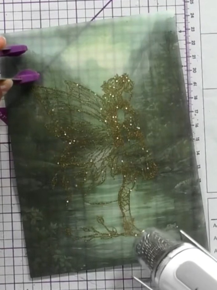 Step 10: Remove the heat gun once the embossing powder has melted completely and allow the vellum to cool. The gold emb