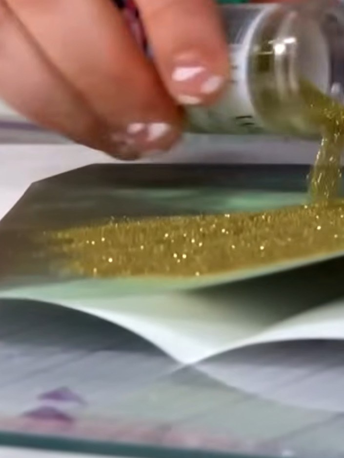 Step 6: Pour gold embossing powder generously over the stamped image on the vellum, ensuring the entire design is cove