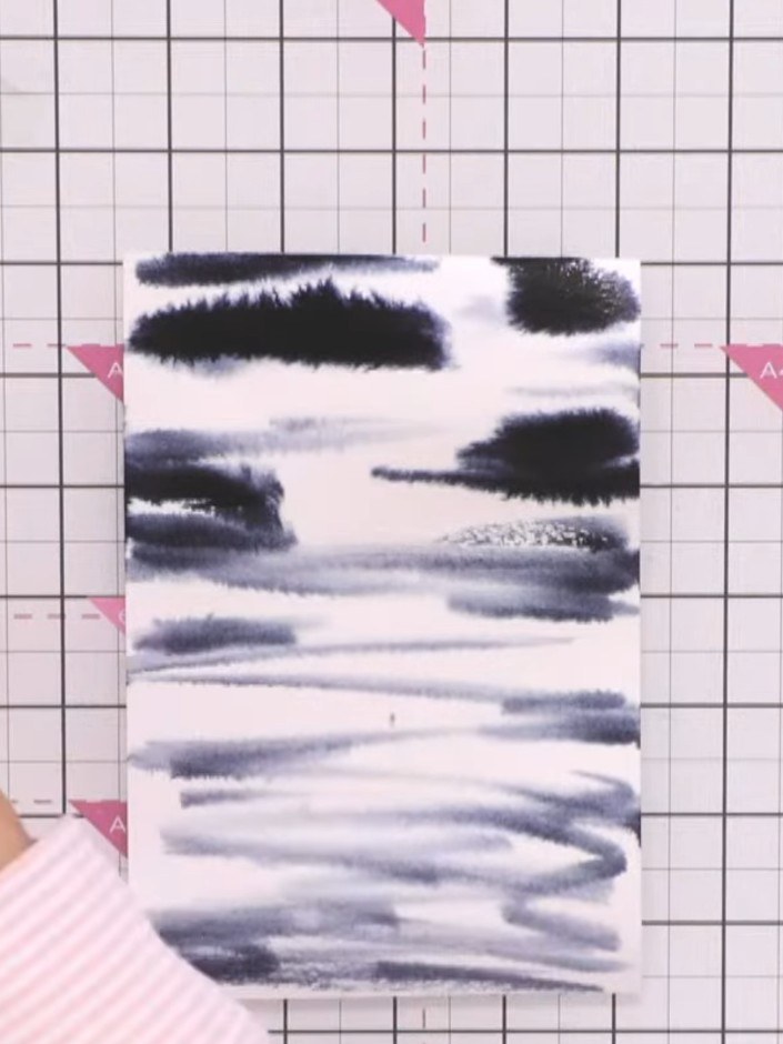 Step 3: Squeeze the steely blue watercolour marker pen to release colour and drop it onto the wet paper, allowing it t
