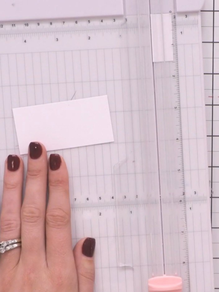 Step 14: Cut a piece of white cardstock measuring 1.5 inches wide by 3 inches long for the closure strip. Layer the whi