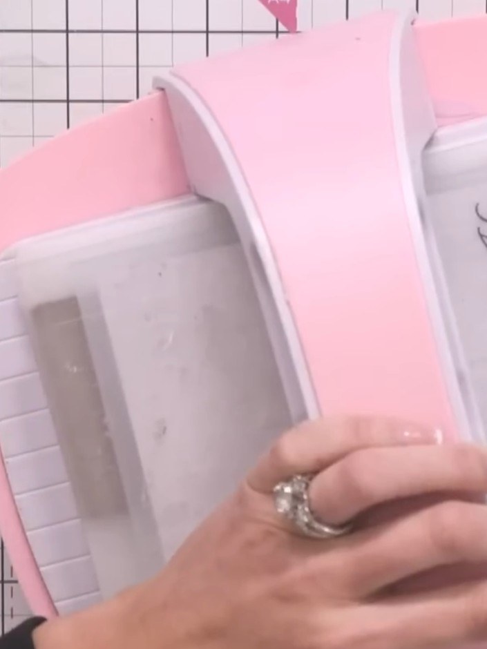 Step 5: Run the embossing folder with the pink cardstock through the die-cutting machine, applying gentle pressure to 