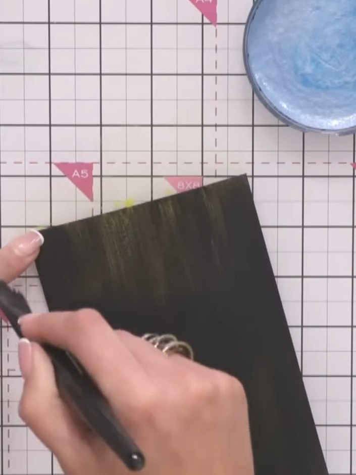 Step 4: Place the inked black cardstock into your embossing folder. A honeycomb swirl pattern works well for this tech