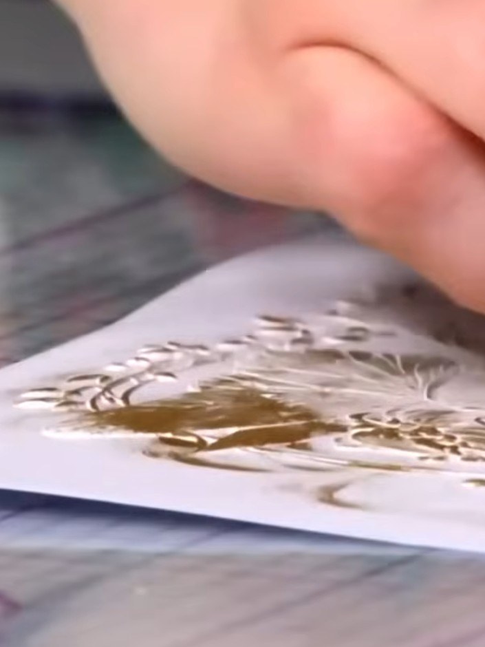 Step 6: Continue building up the gold ink on the embossed design, working it into the raised areas. Use a dabbing moti