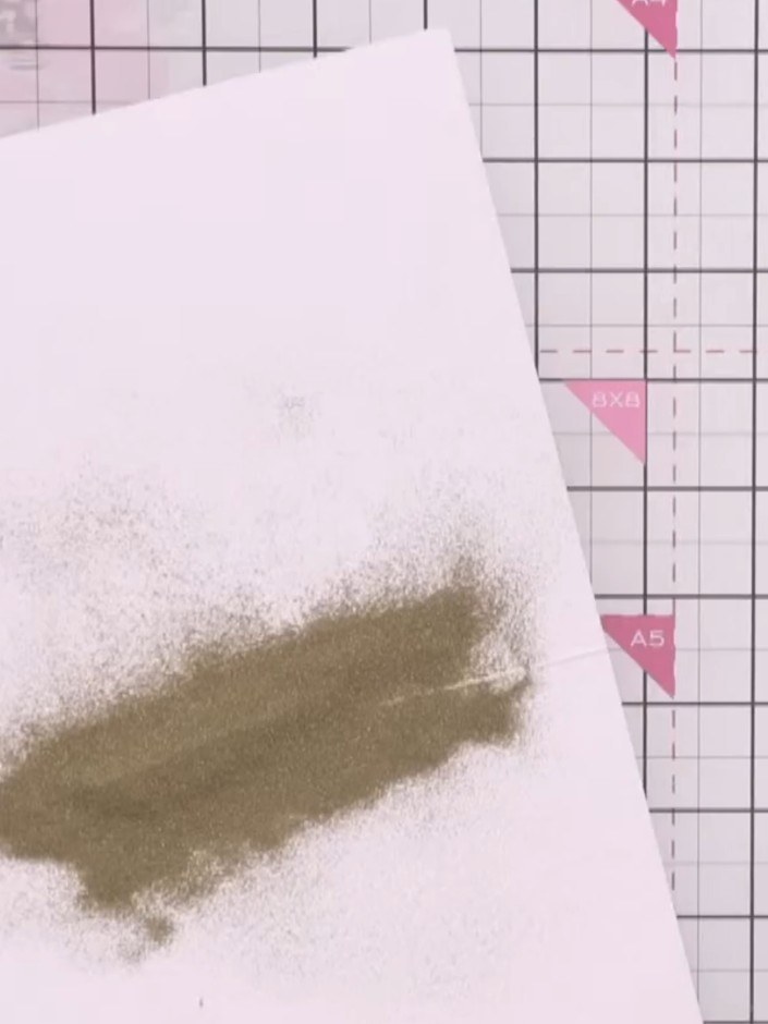 Step 11: Heat set the gold embossing powder with an embossing gun, holding it close to the surface until the powder mel